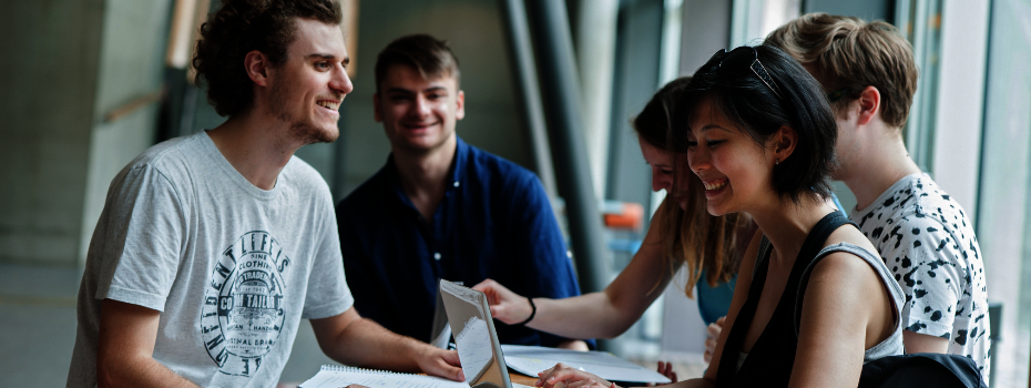 Studierende arbeiten und lachen an der Universität.